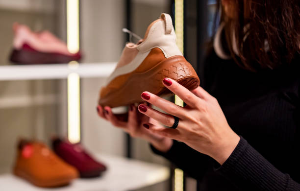 young woman choosing sneakers shoes at store